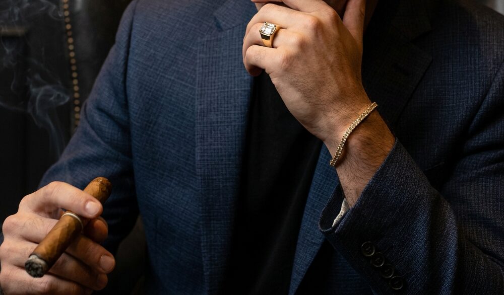 Heavy gold ring with an emerald-cut diamond and a gold tennis bracelet, worn